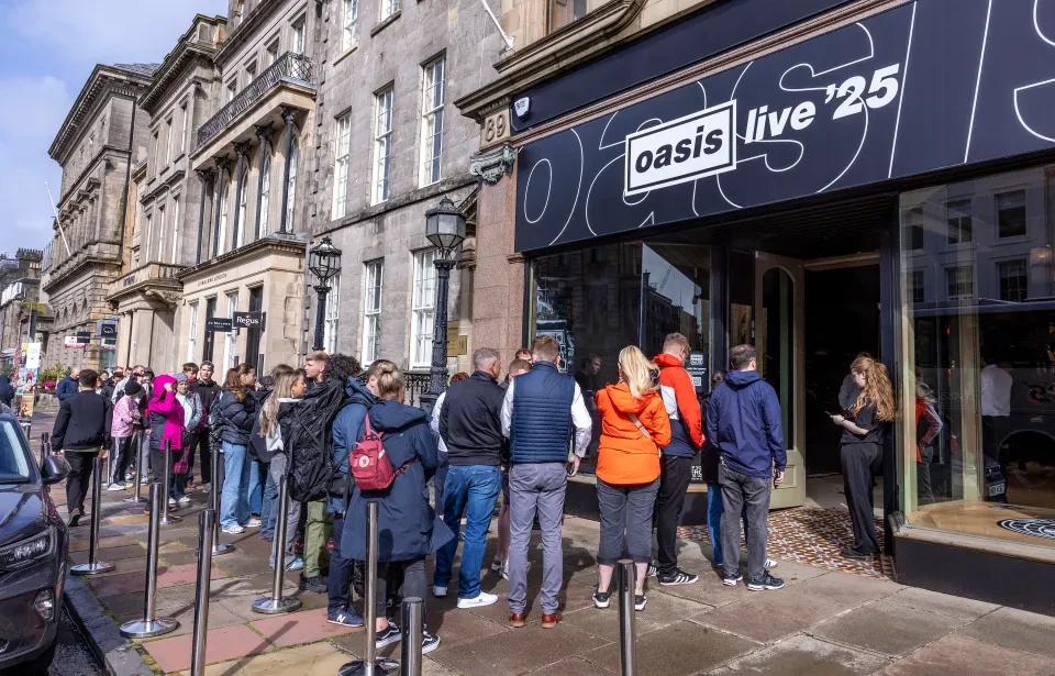 Centinaia di fan degli Oasis fanno la fila per accaparrarsi il merchandising dei concerti, mentre inizia a diffondersi l'entusiasmo in vista degli spettacoli di Edimburgo